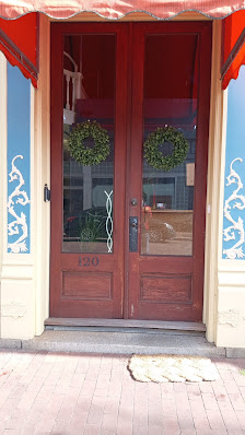 Red double-door entrance to the salon on East Fisher Street